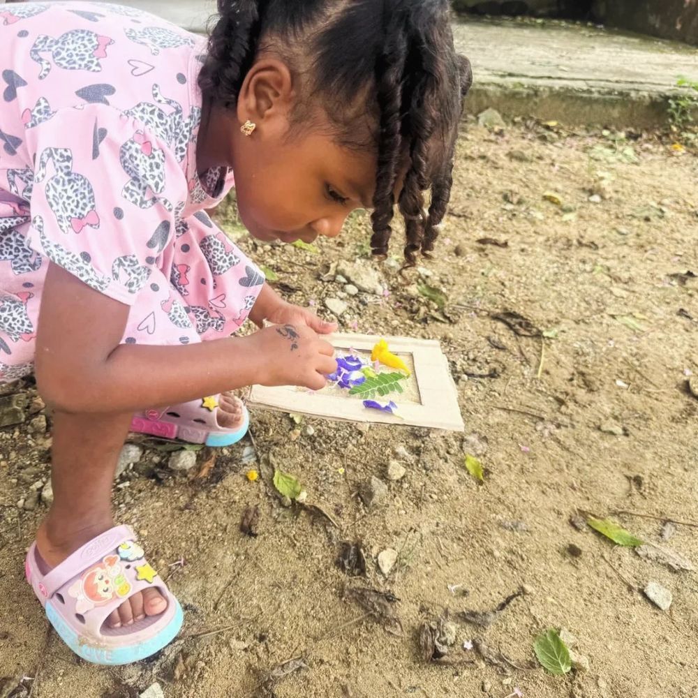 Niña creando un cuadro con flores