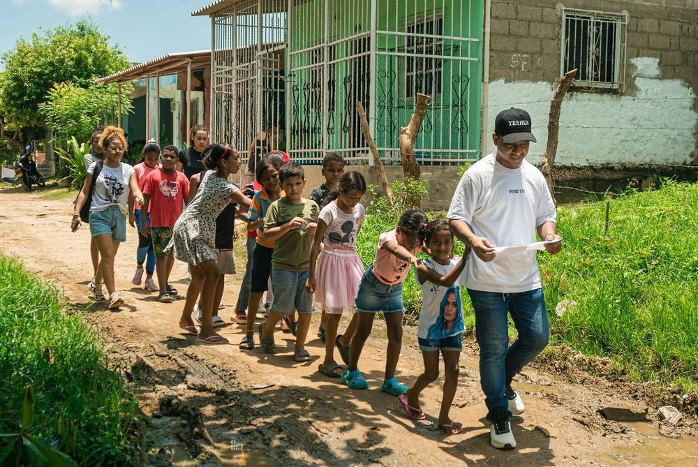 Niños caminando con un voluntario durante una jornada en el barrio