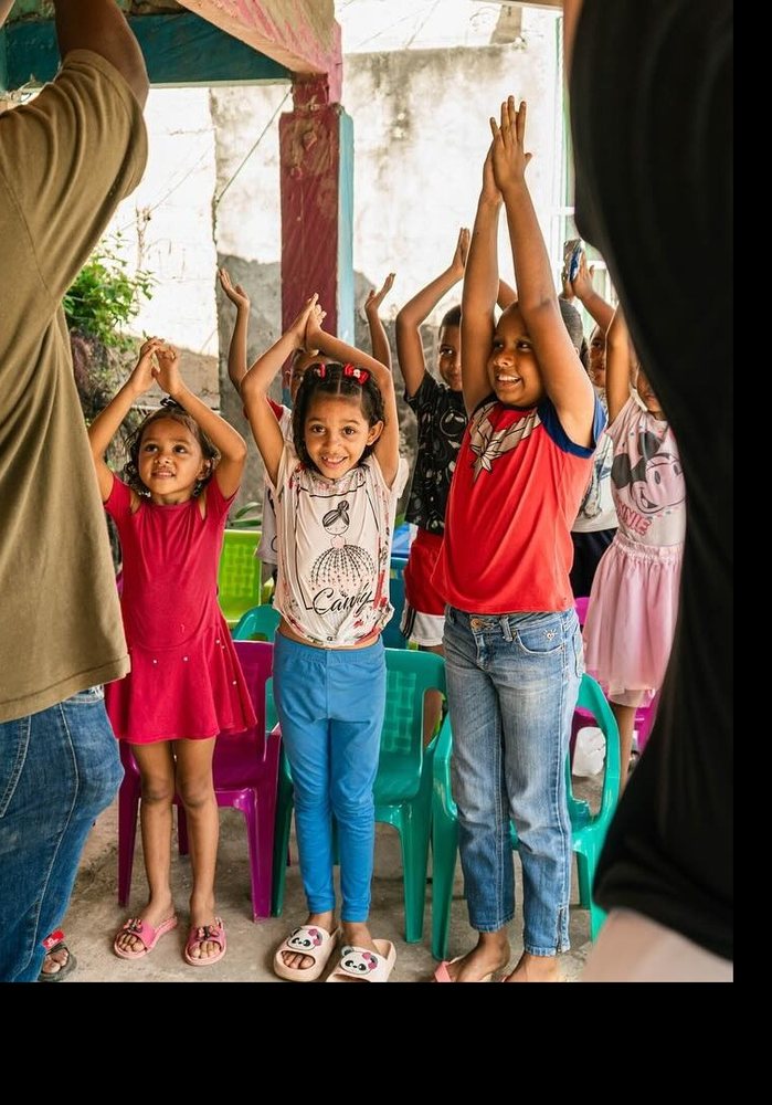 Niños de Somos Arte con los brazos en alto